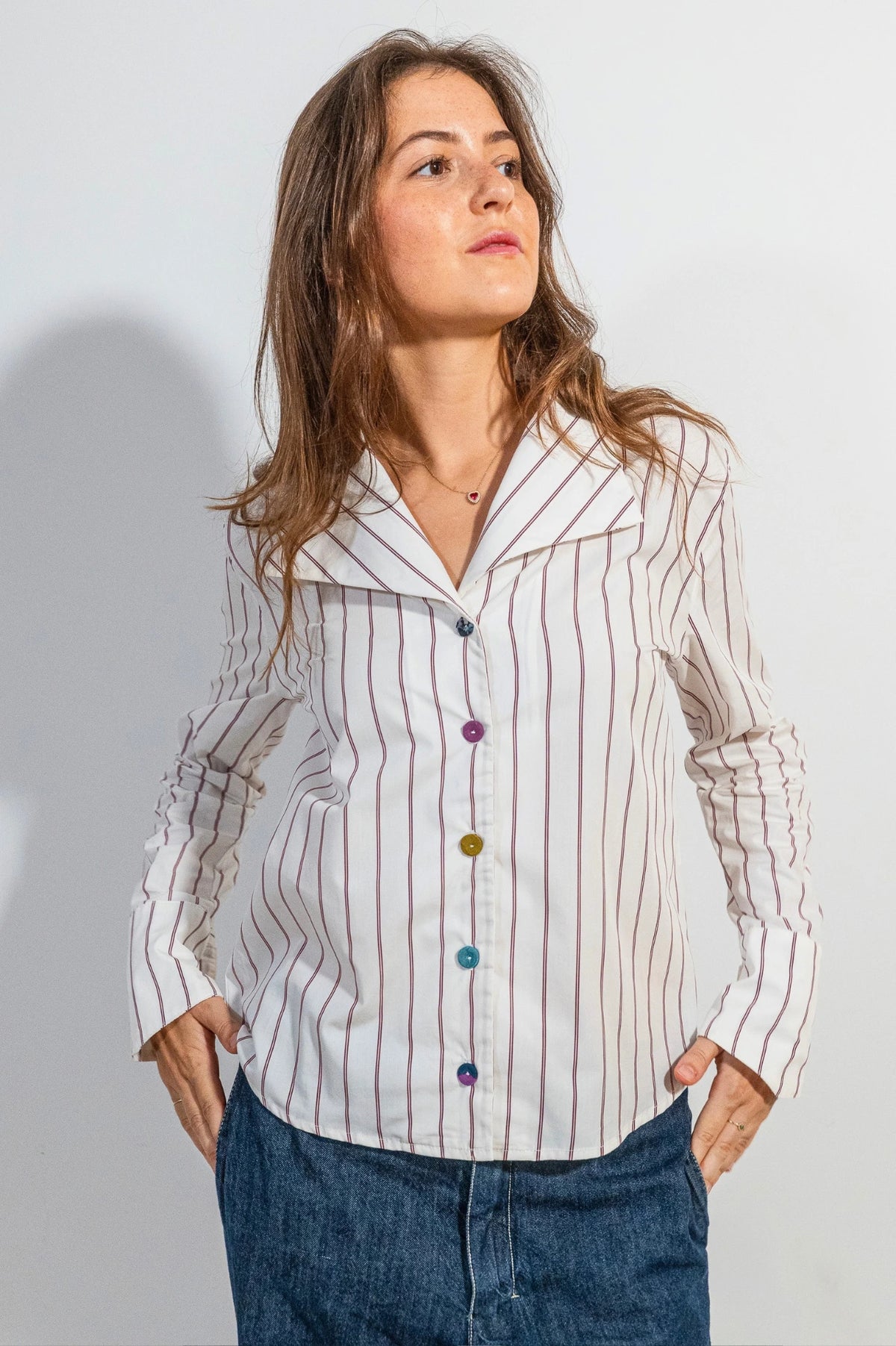 Camisa Rebeca de ATEM, blanca con rayas dobles ciruela, cuello de solapa en V y cinco botones forrados de retales.