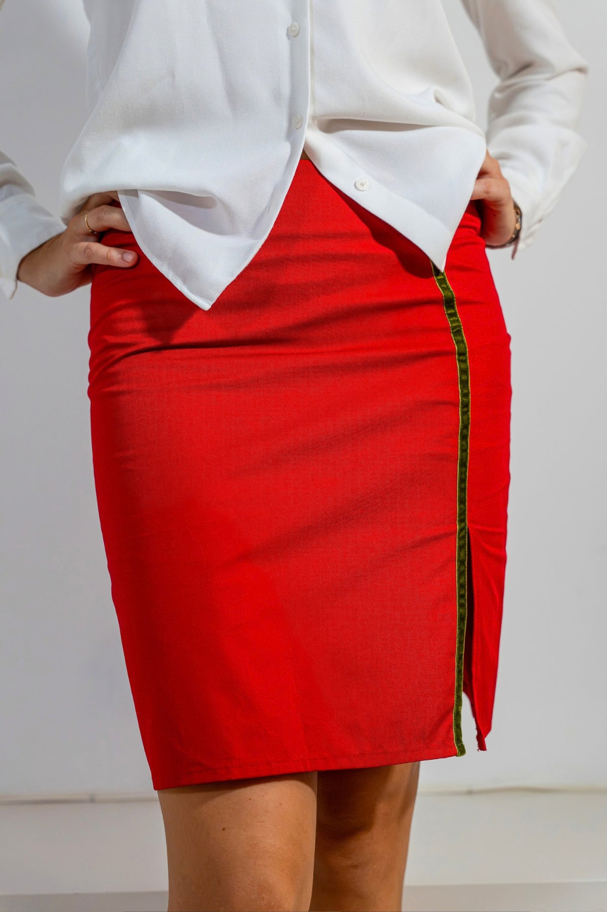 Falda recta Clara de ATEM en algodón rojo, de talle alto, con franja de terciopelo verde oliva y abertura delantera