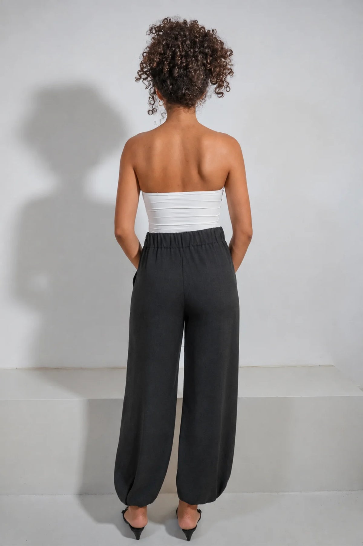 Pantalón Lido de ATEM en Tencel negro, silueta globo con aberturas largas en las piernas y terciopelo verde oliva